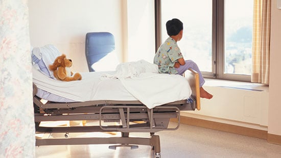 Hospitales y centros quirúrgicos - chico mirando por la ventana sentado en una cama de hospital
