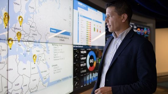 Man in suit reviews reporting data on screens - Ecolab reporting resources