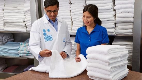 Image of Ecolab employee with on-premise laundry employee looking at a towel.