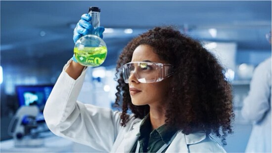 researcher looking at liquid in a test tube